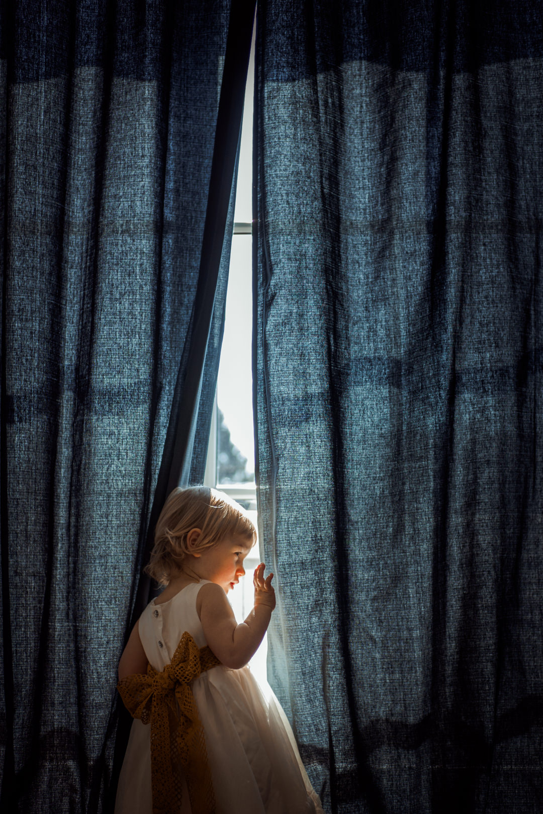 Ciekawość dziecka. Dziewczynka przy oknie. Portret dziecka. Fotografia rodzinna Białystok. Patrycja i Augustyn